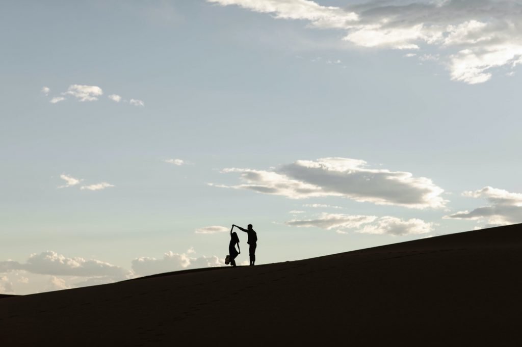 silhouette of a couple during their sand dunes engagement photos