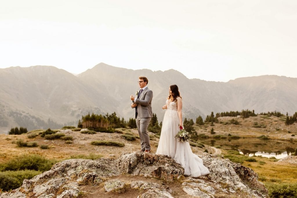 couple popping champagne during their sunrise elopement near Keystone