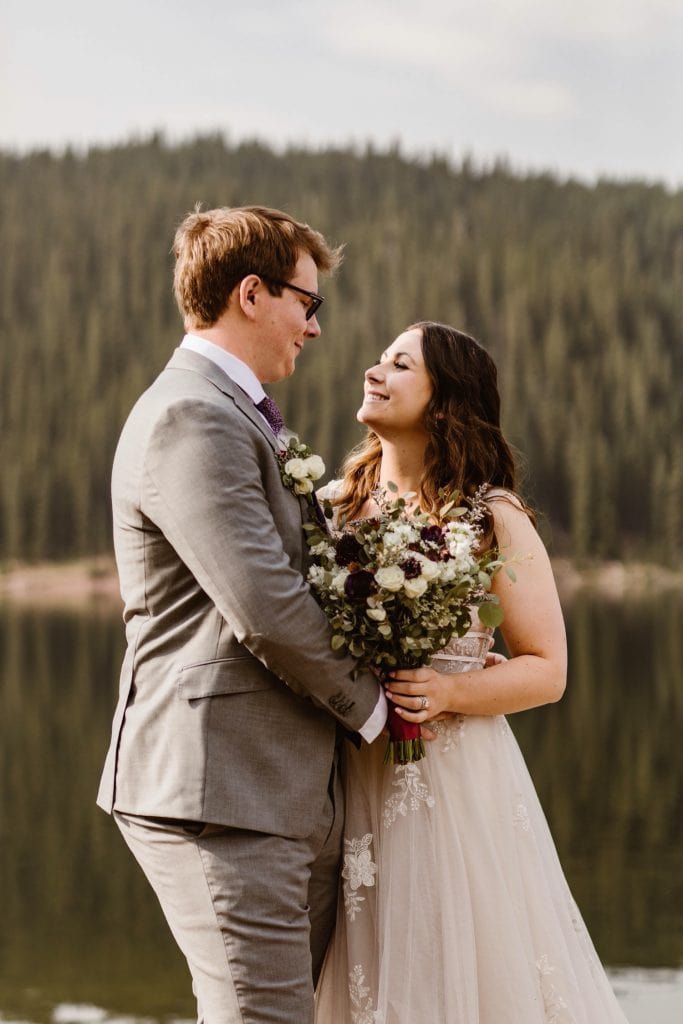 couple standing by a lake near Breckenridge after they eloped at sunrise