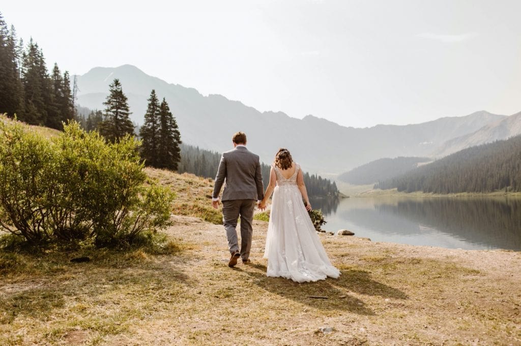 couple walking by a lake near Breckenridge after they eloped at sunrise