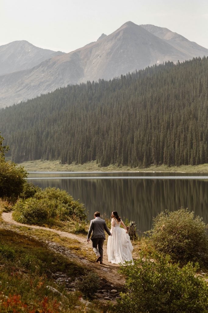 couple walking by a lake near Breckenridge after they eloped at sunrise
