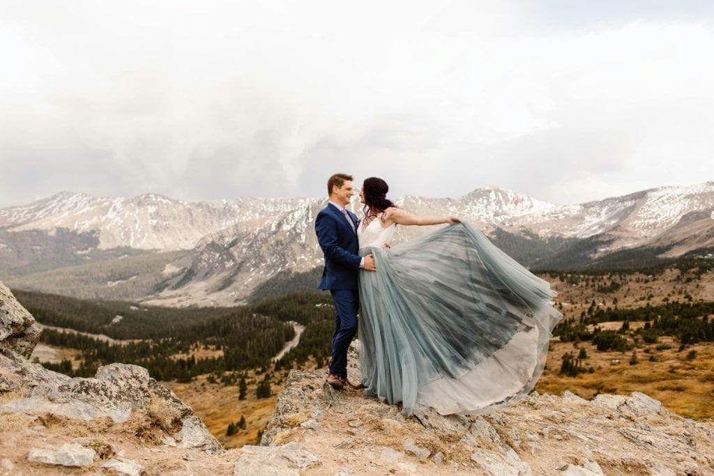 couple standing on the edge of a cliff in the mountains before their Buena Vista elopement ceremony