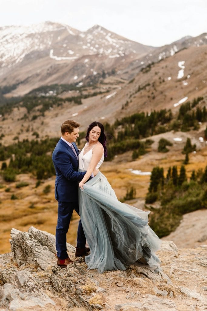 couple standing on the edge of a cliff in the mountains before their Buena Vista elopement ceremony