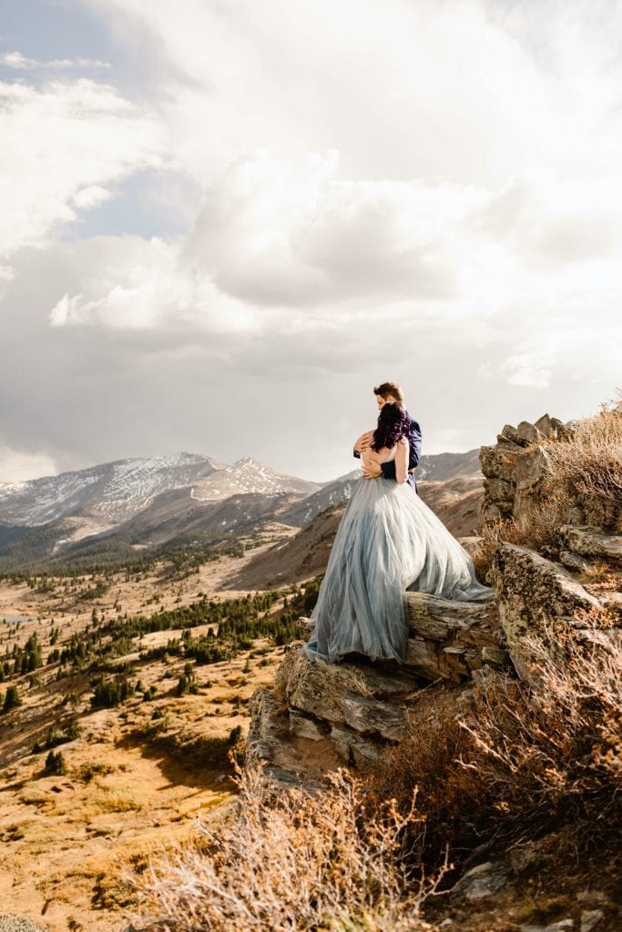 bride and groom hugging each other on the edge of a cliff on their elopement day in Buena Vista Colorado