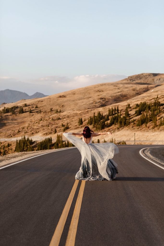 bride walking down a mountain road in Buena Vista Colorado in her flowy wedding dress