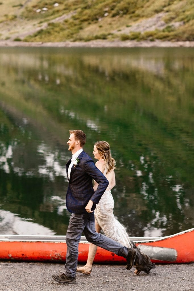 Crested Butte elopement adventures | couple running down the shoreline of an alpine lake in CB