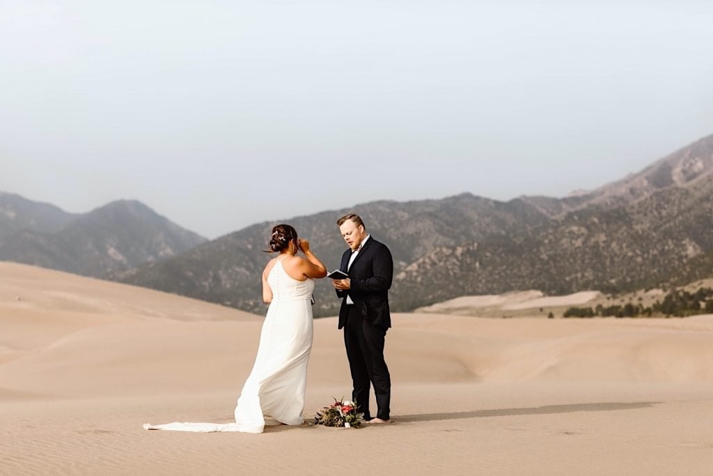 bride and groom reading notes from non-present family members during their Great Sand Dunes National Park elopement ceremony