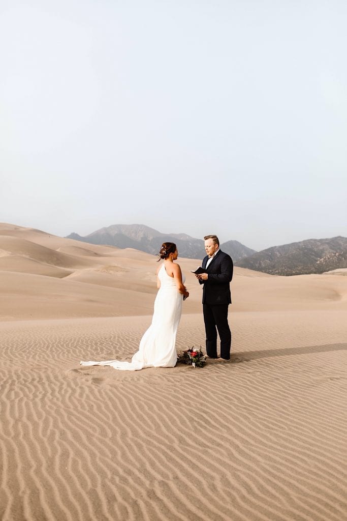 groom reading his vows to the bride during their Great Sand Dunes National Park elopement ceremony