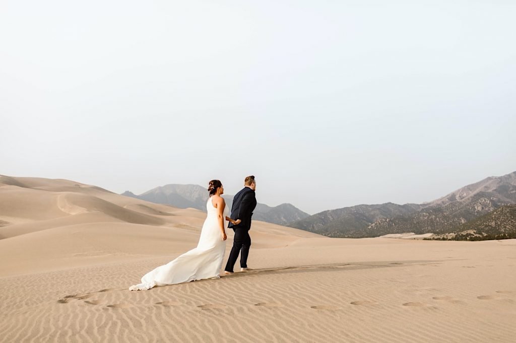 bride and groom walking away from their Great Sand Dunes National Park elopement ceremony site