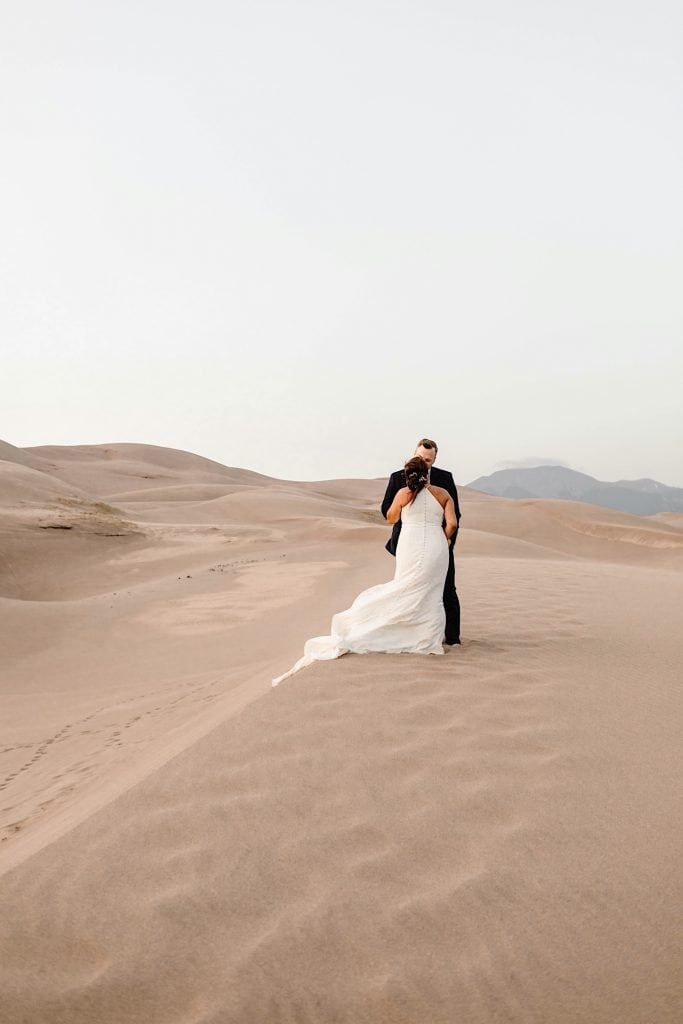 couple kissing on the edge of a dune during their Great Sand Dunes National Park elopement