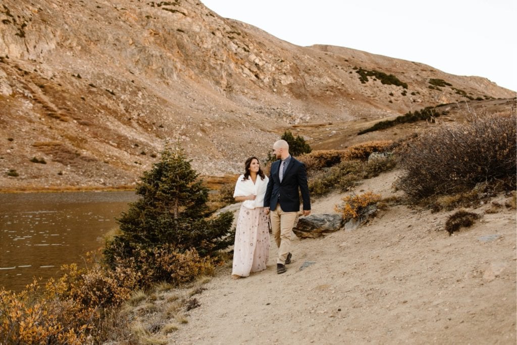 eloping couple walking together down a hiking trail after their Colorado micro wedding ceremony
