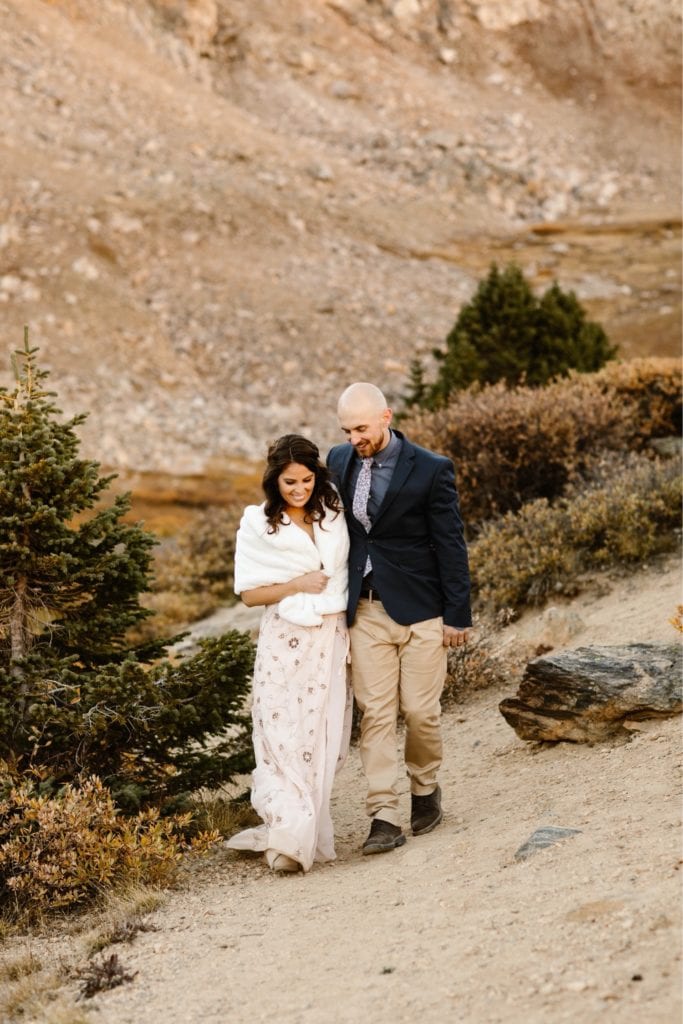 eloping couple walking together down a hiking trail after their Colorado micro wedding ceremony