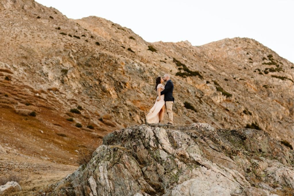 Colorado micro wedding couple standing on the edge of a giant rock in the mountains