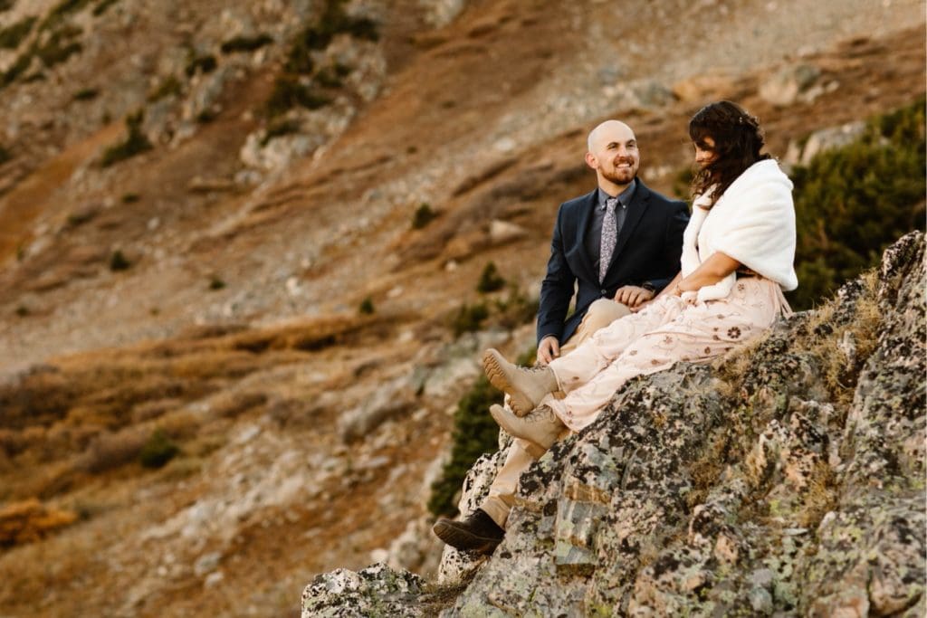 micro wedding couple sitting on the edge of a rock enjoying each other's company