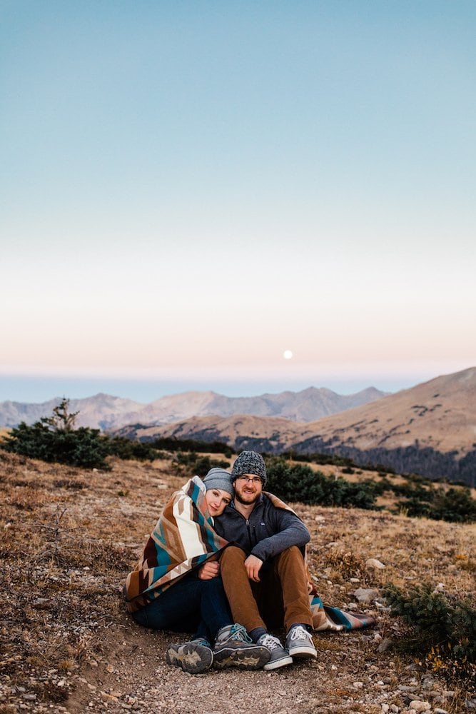 couple sitting on a hiking trail in the alpine tundra of Colorado Rocky Mountains before their adventure elopement