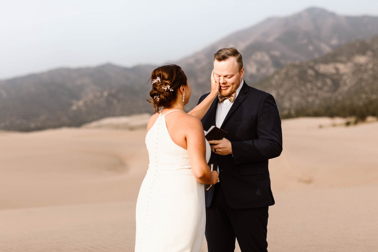couple reading the elopement vows they wrote to each other for their wedding ceremony