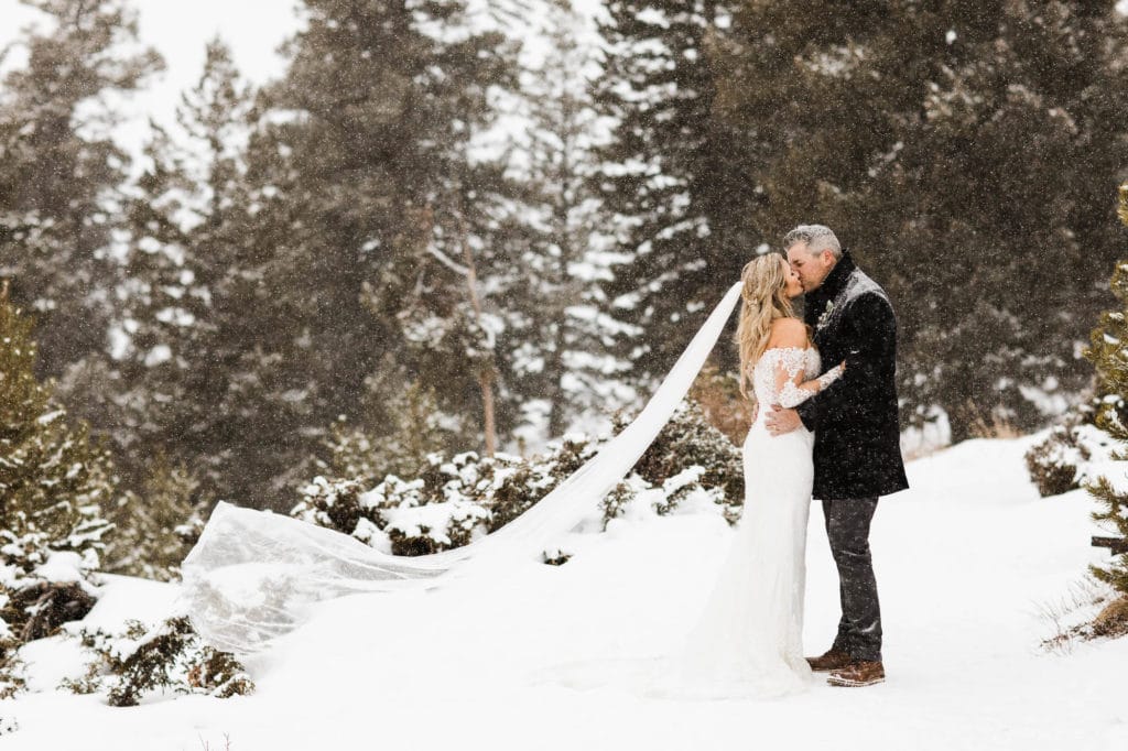 winter elopement couple kissing in the snow