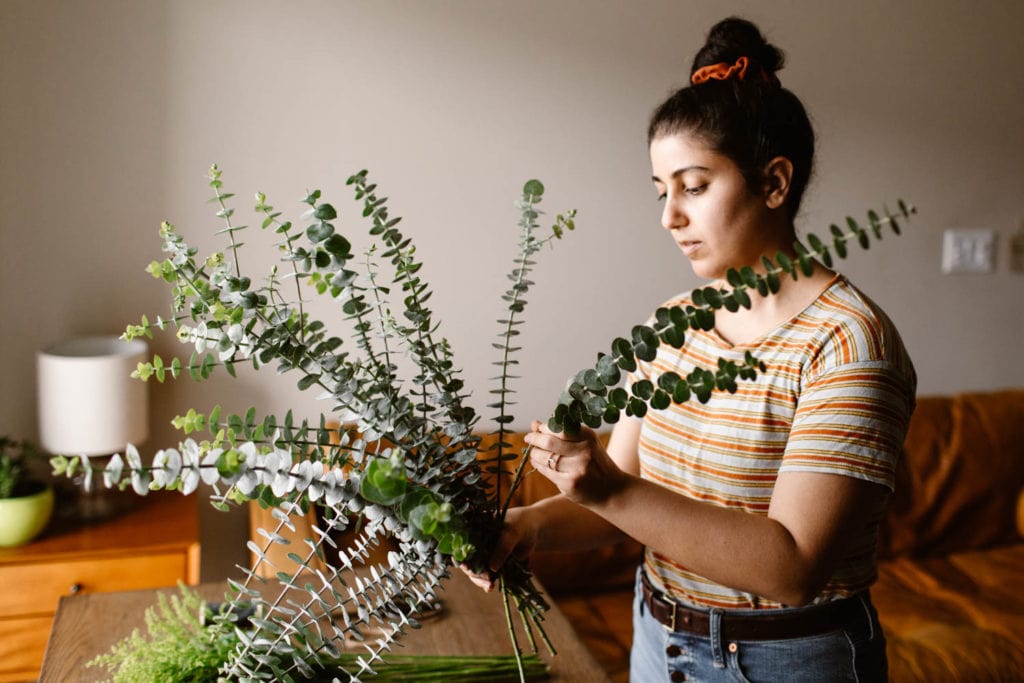 woman adding eucalyptus from Trader Joes to a diy wedding bouquet