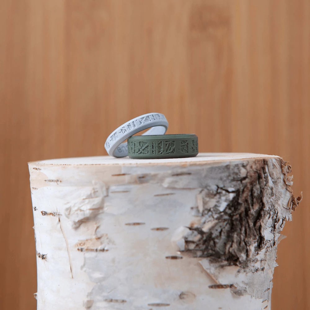 baby blue and forest green best aspen tree silicone wedding bands sitting on an aspen tree stump