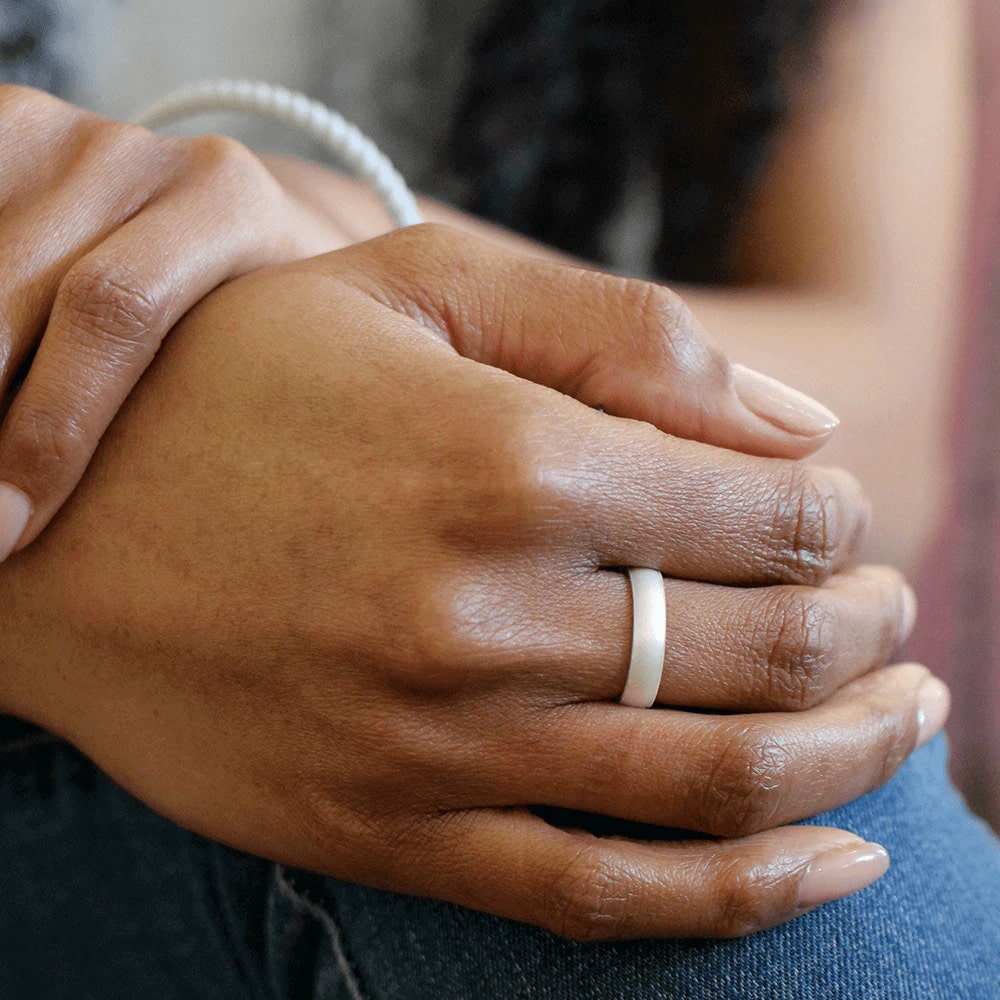 woman wearing a thin white pearl color silicone wedding band