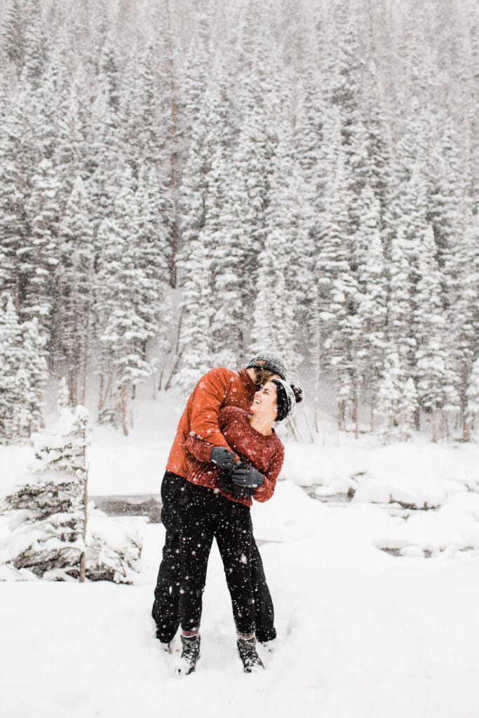 a couple in the snow experiencing a winter wonderland while living in Colorado