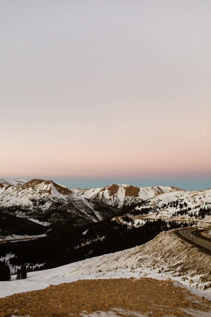 pink sunset over a switchback with a steep drop off on Loveland Pass Colorado