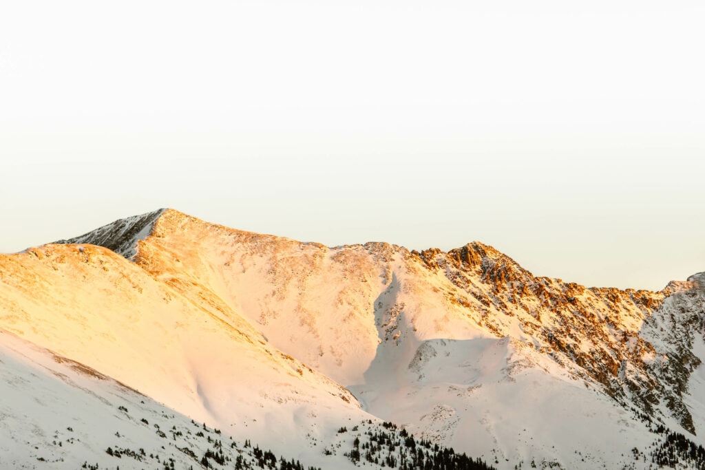 snow covered mountains with alpenglow in winter