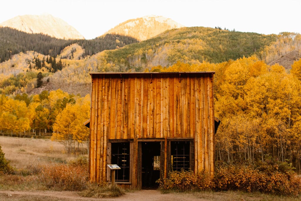 late 1800s wood building in Ashcroft surrounded by aspen covered mountains in gold and green