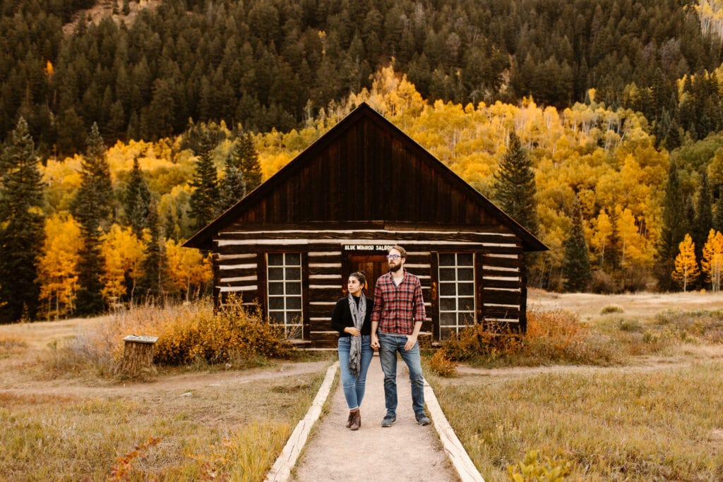 couple standing in front of the historic Blue Mirror Saloon in Ashcroft Ghost Town near Aspen Colorado