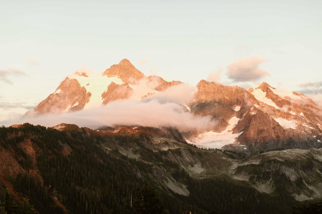 maroon alpenglow on Mt Shuksan as viewed from a hiking trail in the Artist Point Mt Baker area of Washington