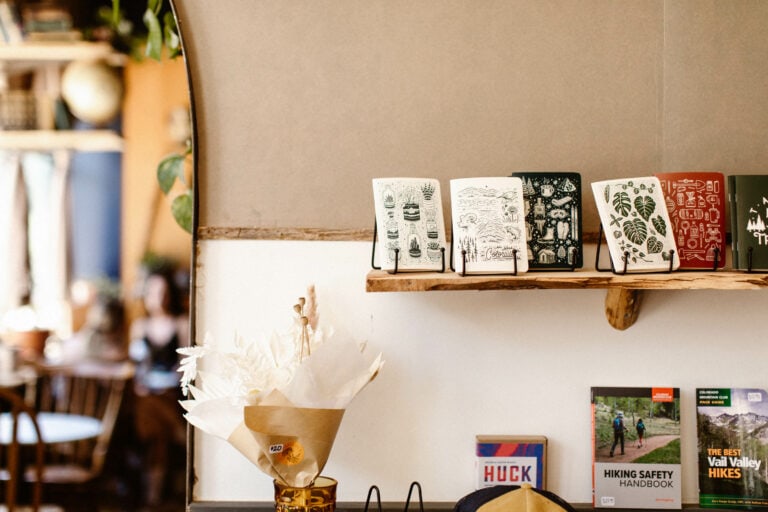 wall mounted shelf in a cafe with nature inspired travel journals propped on it