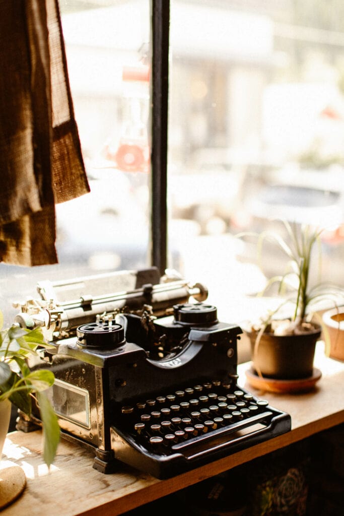 vintage typewriter sitting in the window of a cafe